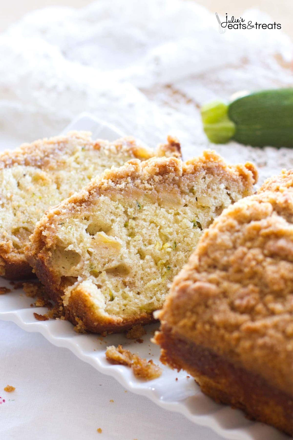 Sliced Crumb Apple Zucchini Bread ~ Easy, Quick Bread Recipe Filled with Fresh Grated Zucchini and Sweet Apples then Topped with Cinnamon Brown Sugar Crumb Topping on a white cloth.