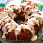 Easy cinnamon roll monkey bread ring with frosting on a metal cake stand