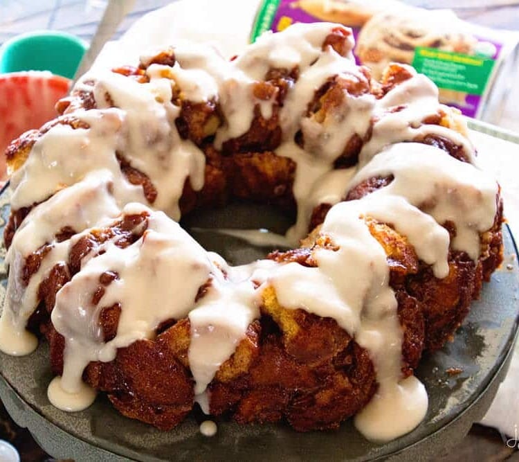 Easy cinnamon roll monkey bread ring with frosting on a metal cake stand