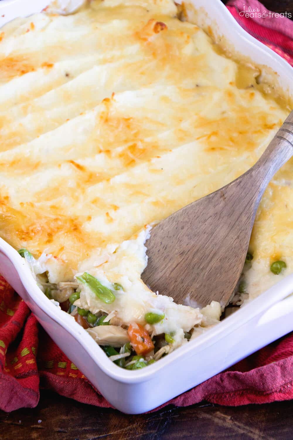 White casserole dish with spatula scooping out leftover turkey shepherd's pie.