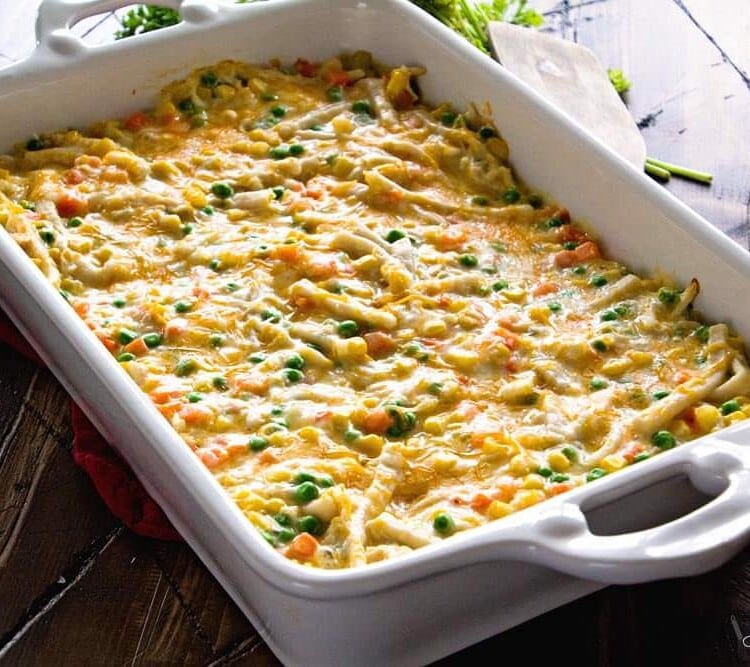Cheesy chicken noodle casserole in a white baking dish