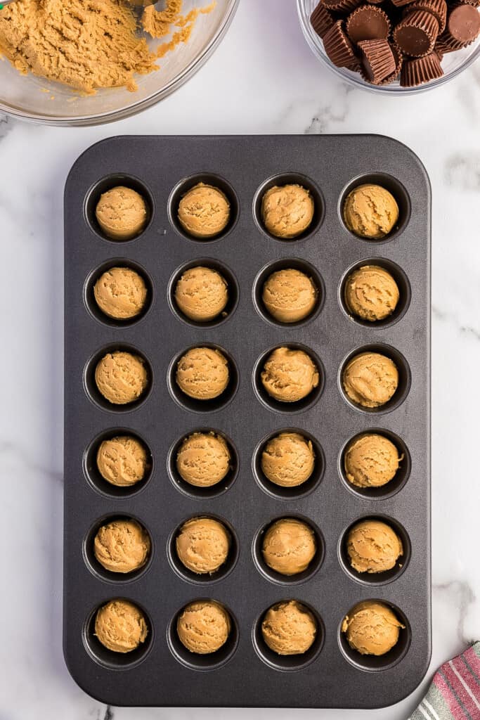 Overhead image of peanut butter cookie dough in mini muffin pan