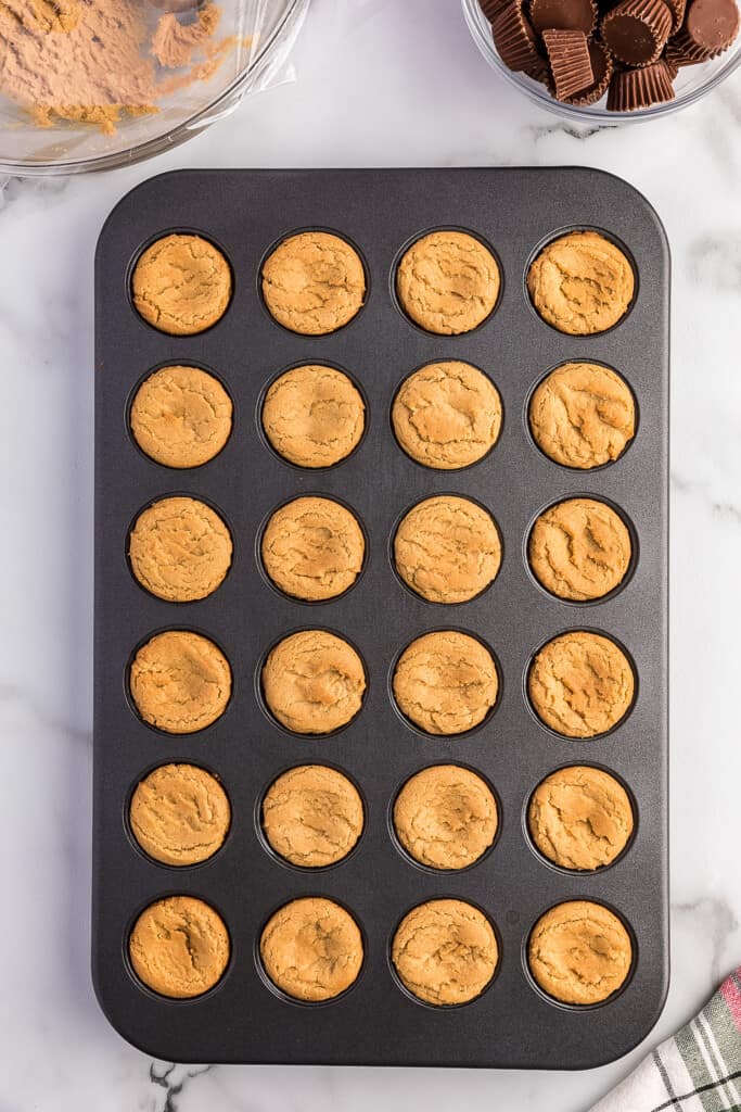 Overhead image of baked peanut butter cookie dough in mini muffin pan