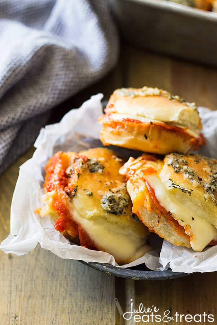 Round bowl with three pepperoni pizza sliders stacked in them.