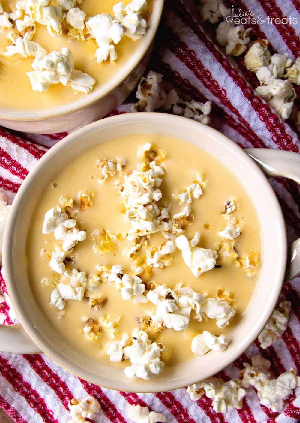 Overhead image of beer cheese soup in a crock bowl and garnished with popcorn.