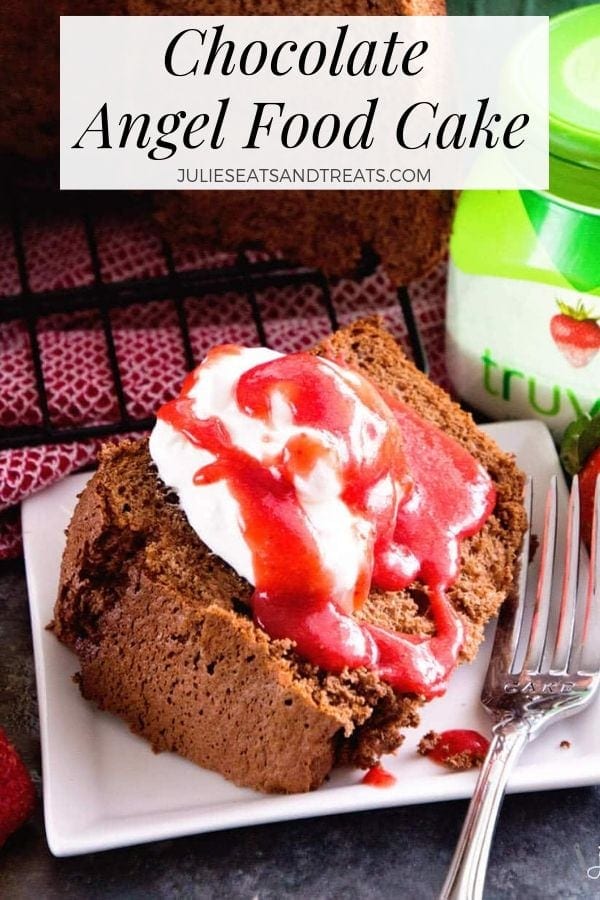 Chocolate angel food cake topped with whipped cream and strawberry sauce on a plate