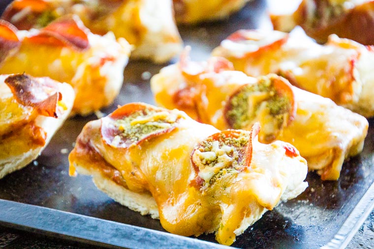 French bread layered with sauce, pepperoni, and cheese on a baking sheet