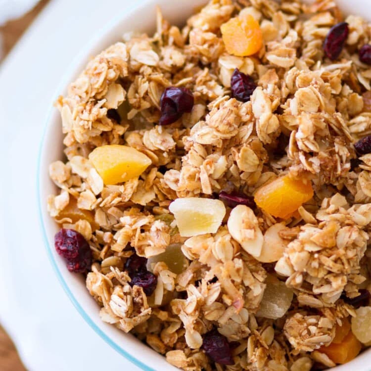 This homemade Tropical Coconut Granola is filled with shredded coconut, coconut oil, and coconut sugar! Dried pineapple, apricots, golden raisins, cranberries, and macadamia nuts give this easy coconut granola a tropical flavor. This homemade granola recipe is so easy, you may never buy store-bought again!