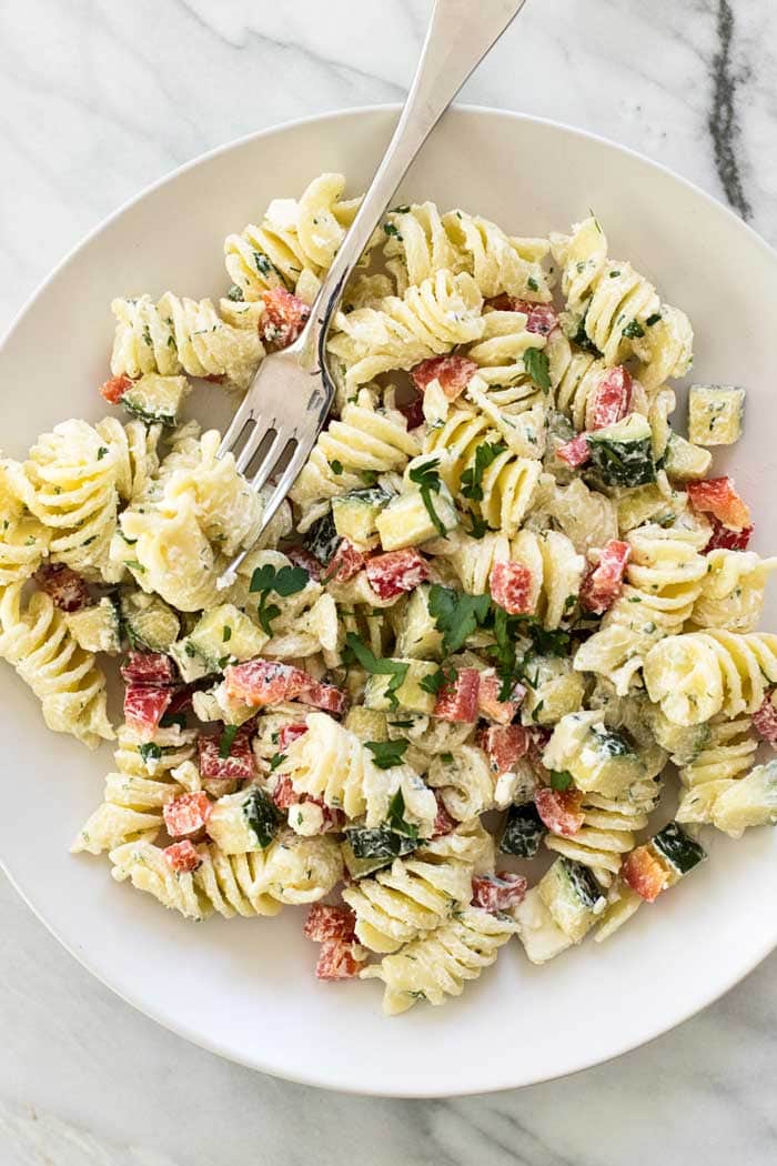 Overhead picture of Greek Pasta Salad on a white plate with a fork.