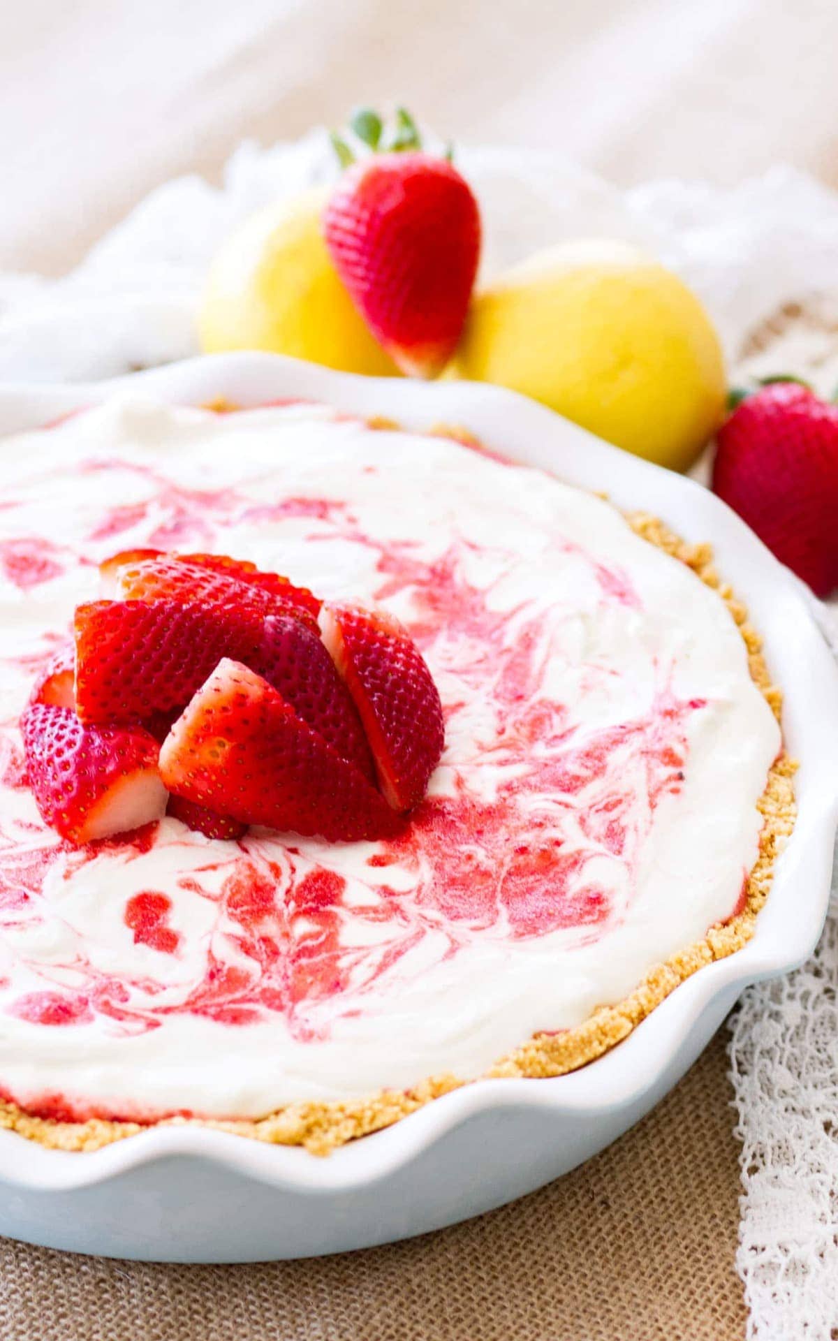 Strawberry Lemonade Pie surrounded by strawberries and lemons. This icebox pie is sweet, a little tangy, and the perfect no-bake dessert for summer!