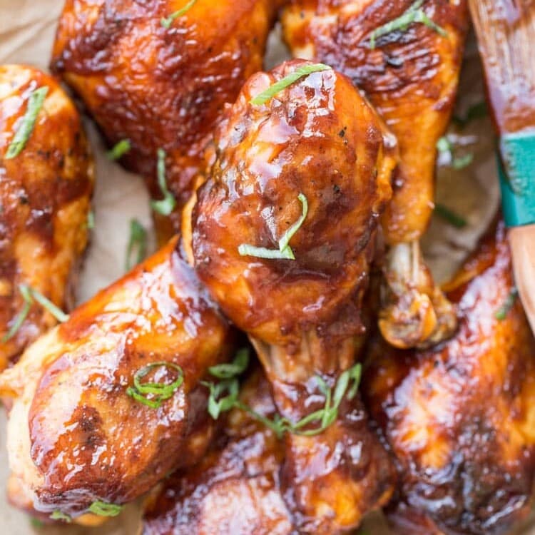 Baked barbecue chicken drumsticks on a white plate