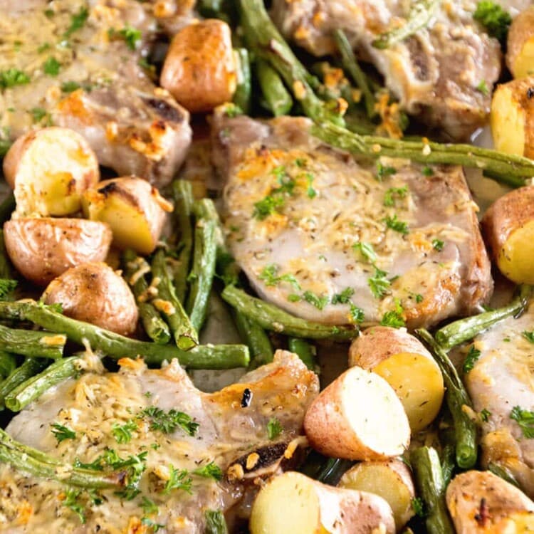One pan parmesan pork chops and vegetables on a baking sheet