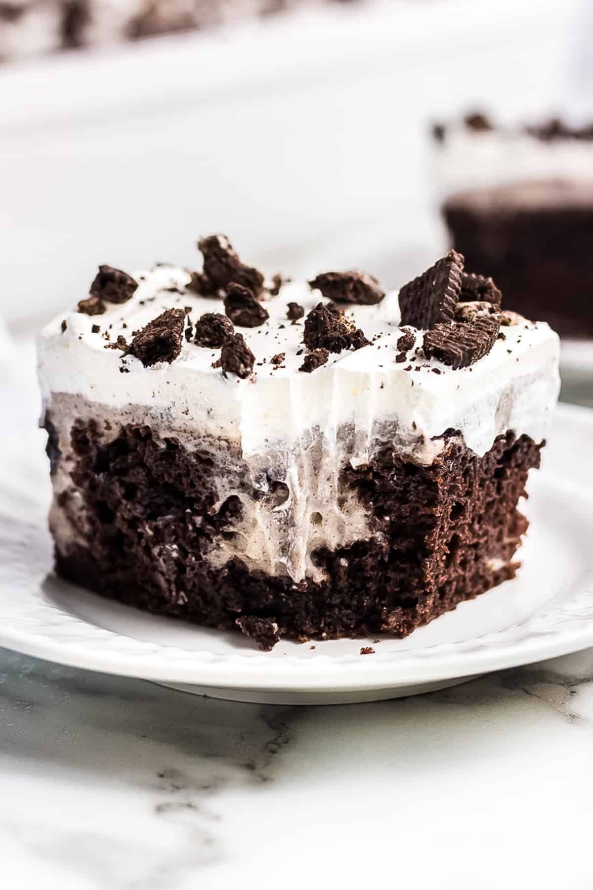 White plate with a piece of oreo poke cake