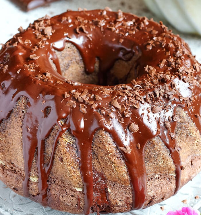 Chocolate Bundt Cake with chocolate icing on a clear glass plate