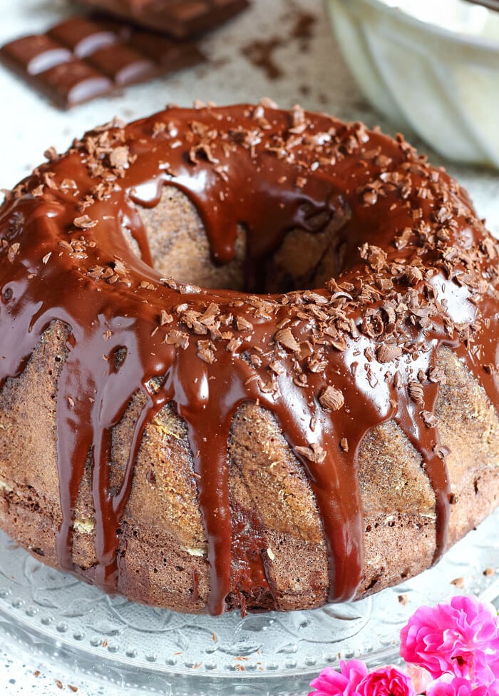 Chocolate Bundt Cake with chocolate icing on a clear glass plate