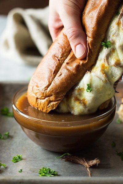 AN EASY RECIPE FOR SLOW COOKER FRENCH DIP SANDWICHES! THESE ARE FILLED WITH TENDER AND FLAVORFUL BEEF, MELTY CHEESE AND A BEEFY AU JUS FOR DIPPING!