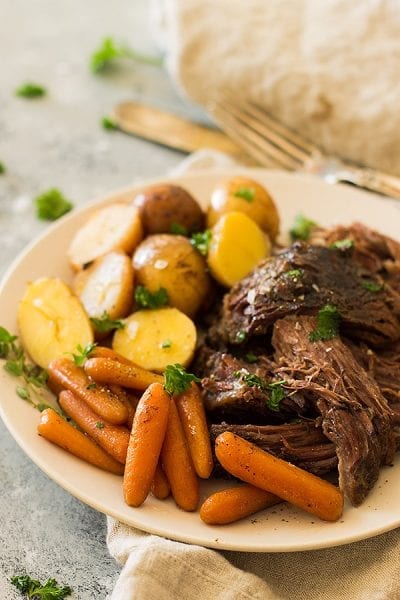 CRAZY TENDER, MELT IN YOUR MOUTH SLOW COOKER POT ROAST WITH CARROTS AND POTATOES. THIS SUPER EASY MEAL REQUIRES LITTLE PREP AND THE CROCKPOT DOES ALL THE WORK! 