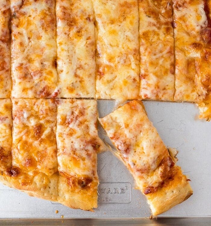 Overhead image of a batch of four cheese pizza dunkers on a metal sheet pan