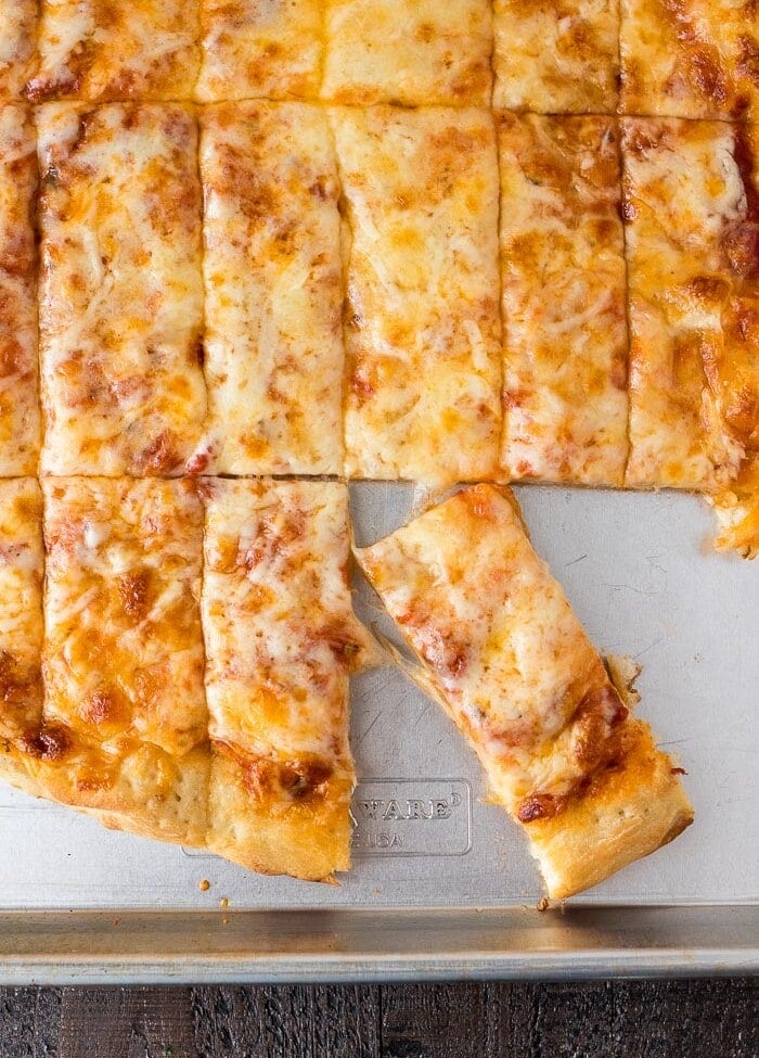 Overhead image of a batch of four cheese pizza dunkers on a metal sheet pan