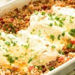 Cheesy Italian chicken and rice casserole in a white baking dish topped with fresh parsley