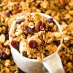 White mug of homemade pumpkin spice granola sitting in a pile of granola