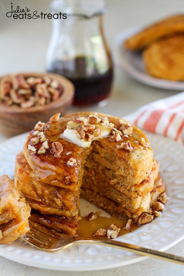 White plate with stack of sweet potato pancakes on ti with a slice taken out.