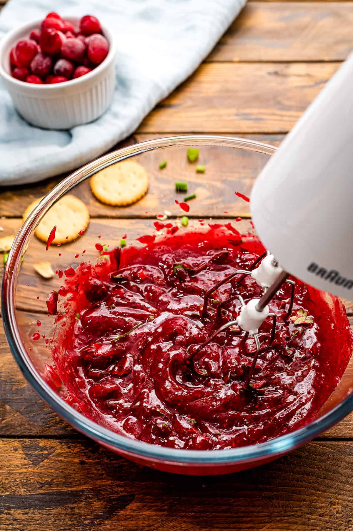 Hand mixer combining ingredients for cranberry dip