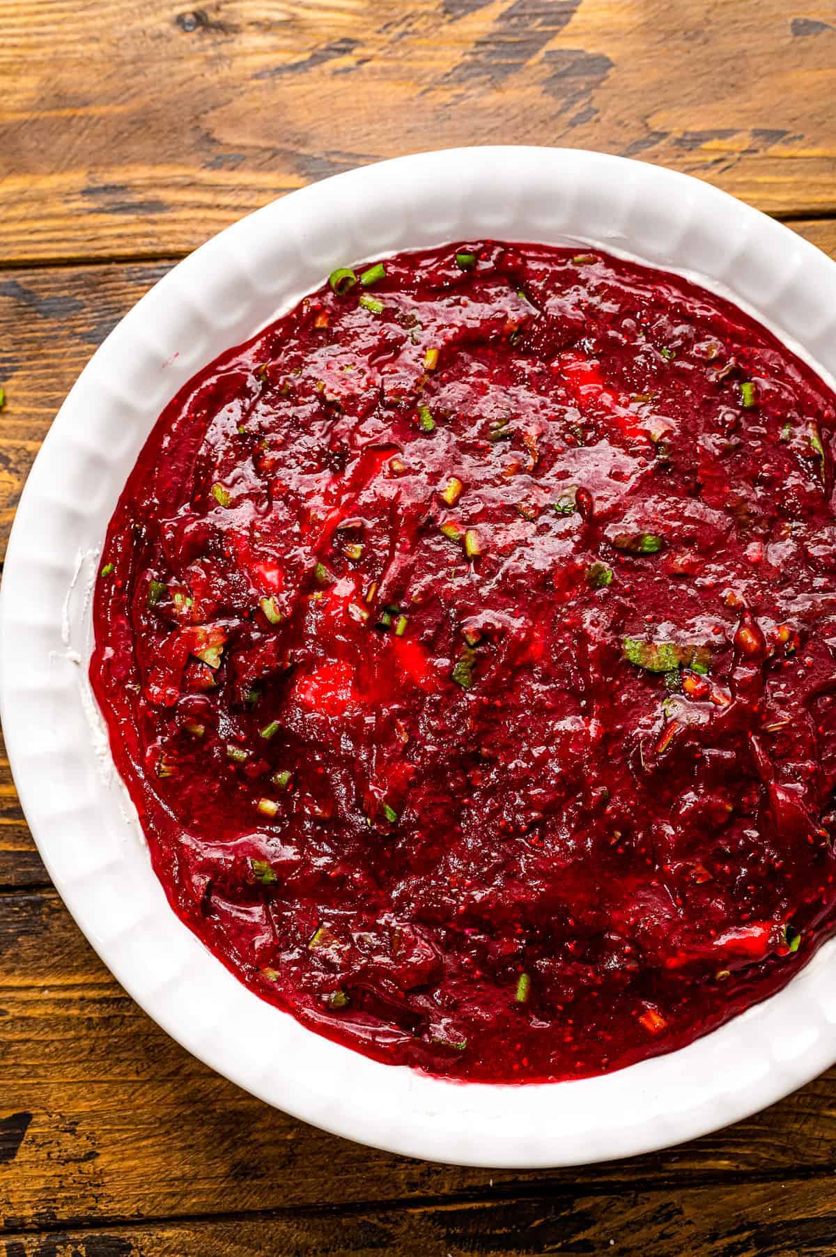 White pie plate with mashed cranberries spread over the bottom.