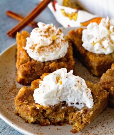 Pumpkin Bars topped with whipped cream on plate