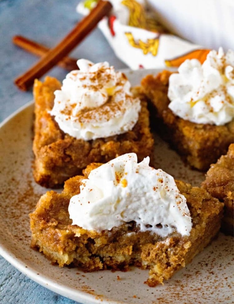 Pumpkin Bars topped with whipped cream on plate
