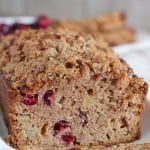 A partially sliced loaf of Apple Cranberry Bread