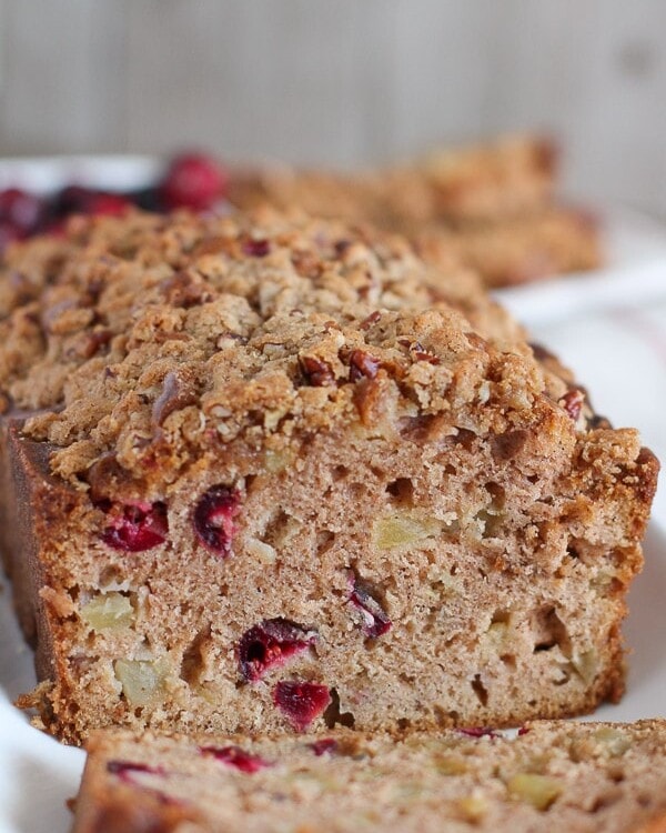 A partially sliced loaf of Apple Cranberry Bread