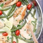 Skillet pan of chicken breasts, green beans, cherry tomatoes, lemon slices, and sauce