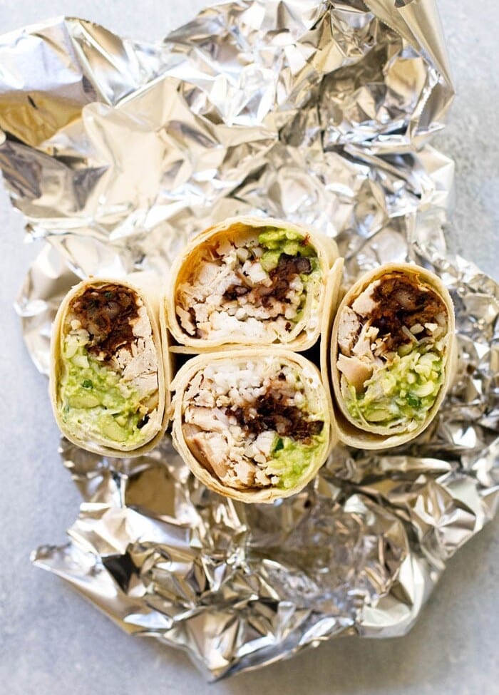 Four halves of Chipotle Black Bean Chicken Burritos on a piece of tin foil