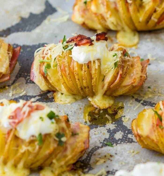 Hasselback potatoes on a parchment paper lined baking sheet