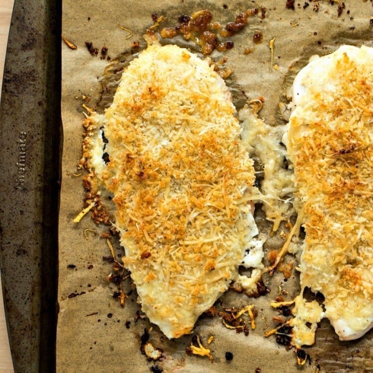 Healthy parmesan crusted chicken breasts on parchment paper