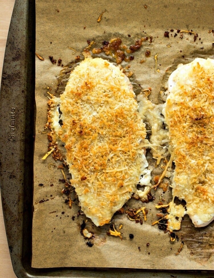 Healthy parmesan crusted chicken breasts on parchment paper