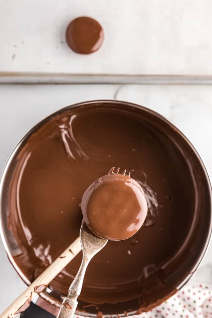 Peanut Butter Ritz cracker being dipped in chocolate