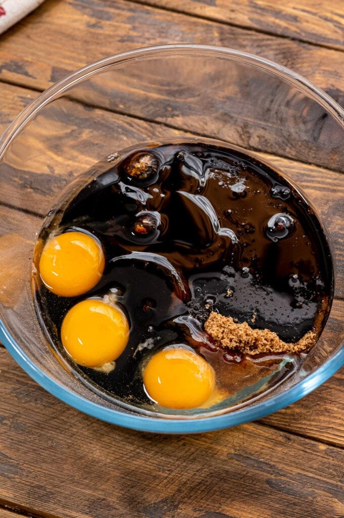 Glass bowl with filling ingredients for pecan pie bars.