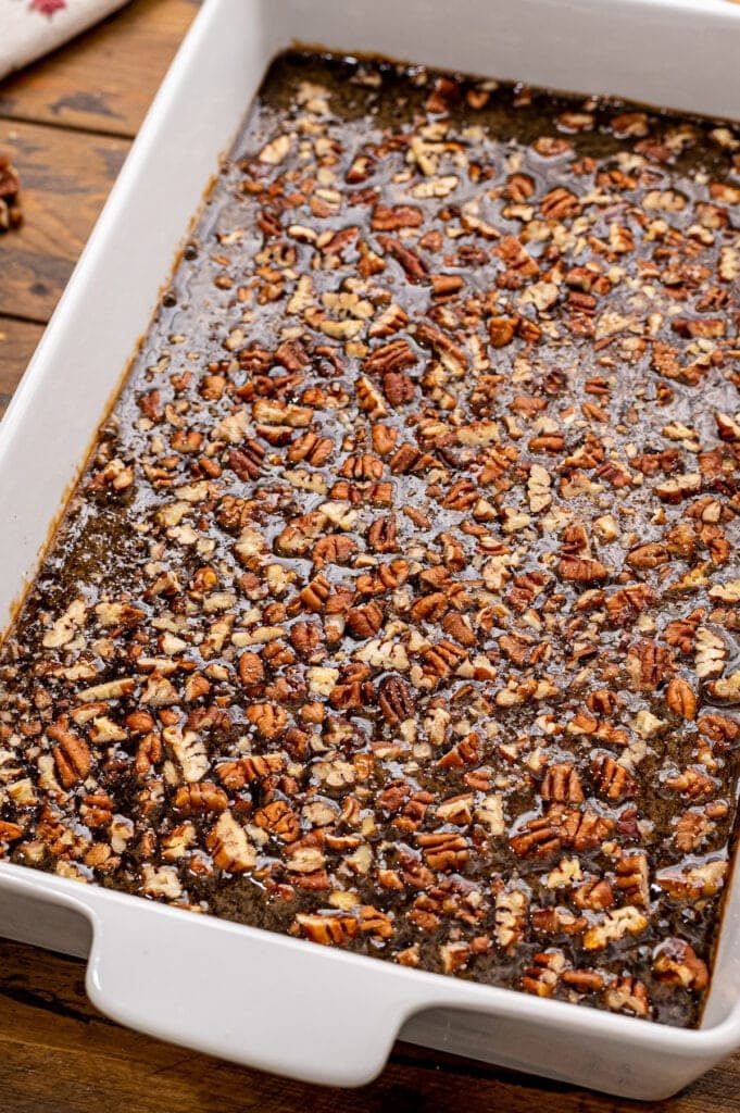 White baking dish with pecan pie bars before baking.