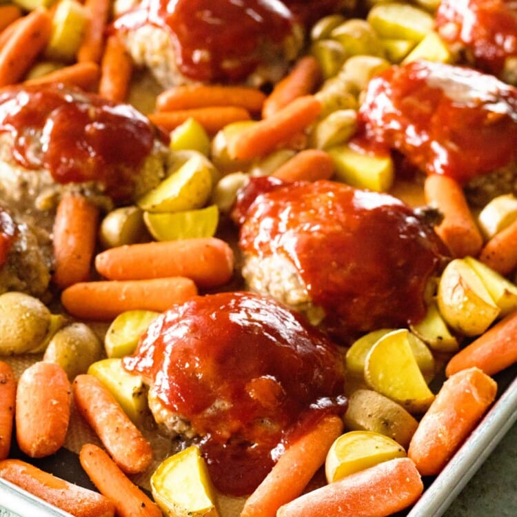 A sheet pan of mini meatloaf and veggies