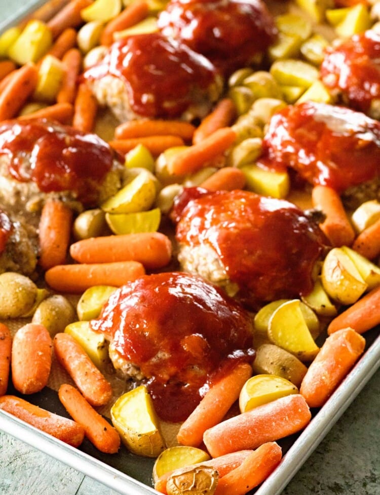 A sheet pan of mini meatloaf and veggies