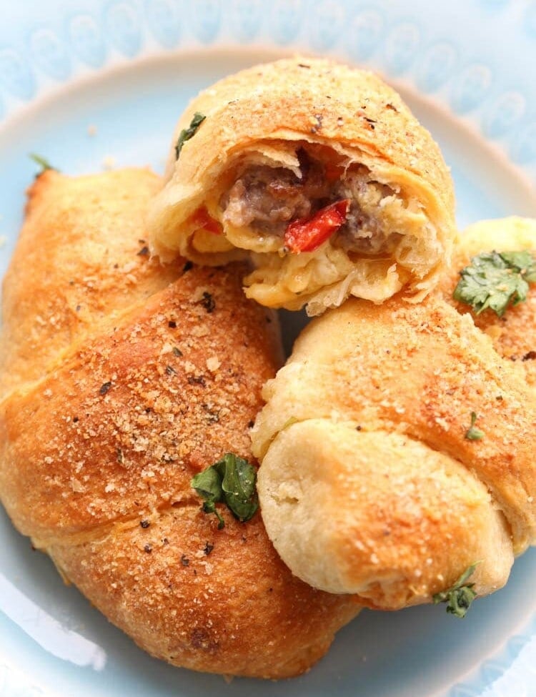 Three Crescent Rolls with Sausage, Peppers, Egg and Cheese Filling on a blue plate