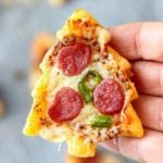 Hand holding a Christmas tree mini pizza with pepperoni