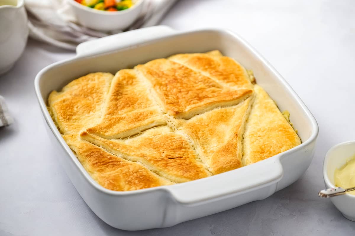 White casserole dish with baked chicken pot pie casserole