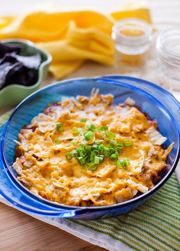 Mexican casserole in a blue glass dish on a green towel