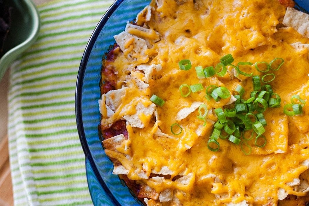 Mexican Casserole with beef, beans, cheese, chips, and sauce.
