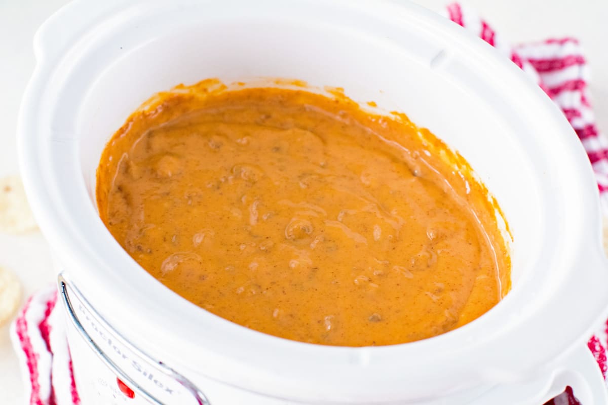 White Crock Pot with prepared chili cheese dip in it
