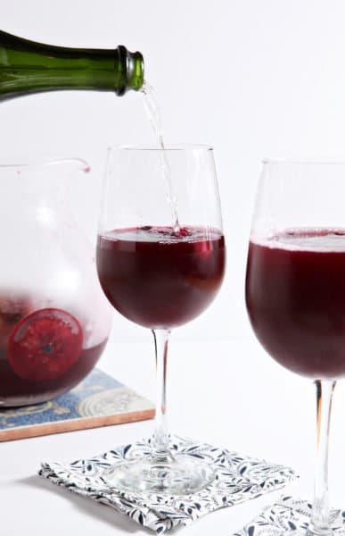 Winter sangria, chock full of orange and cranberry goodness, is combined with a favorite bottle of bubbly to create this cocktail. Spicy and not too sweet, Winter Sparkling Champagne Sangria is a perfect cold weather mixed drink!