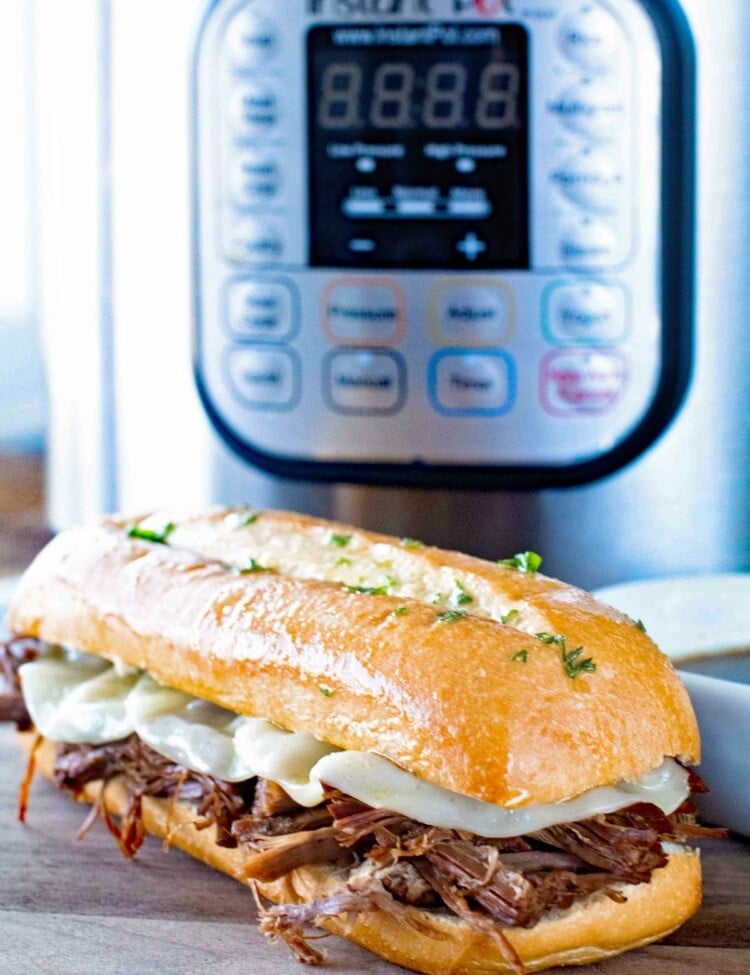 French Dip Sandwich in front of a Pressure Cooker